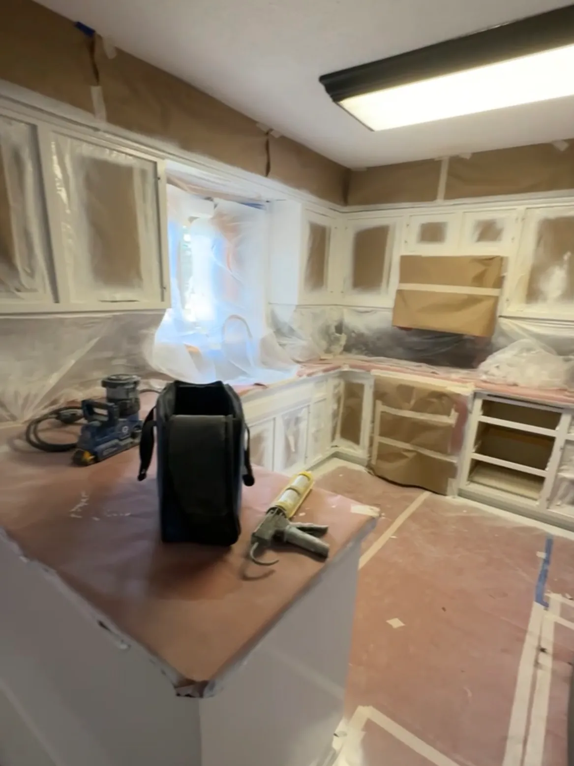The Andover kitchen in progress, sealed off and masked with paper and plastic before spraying.