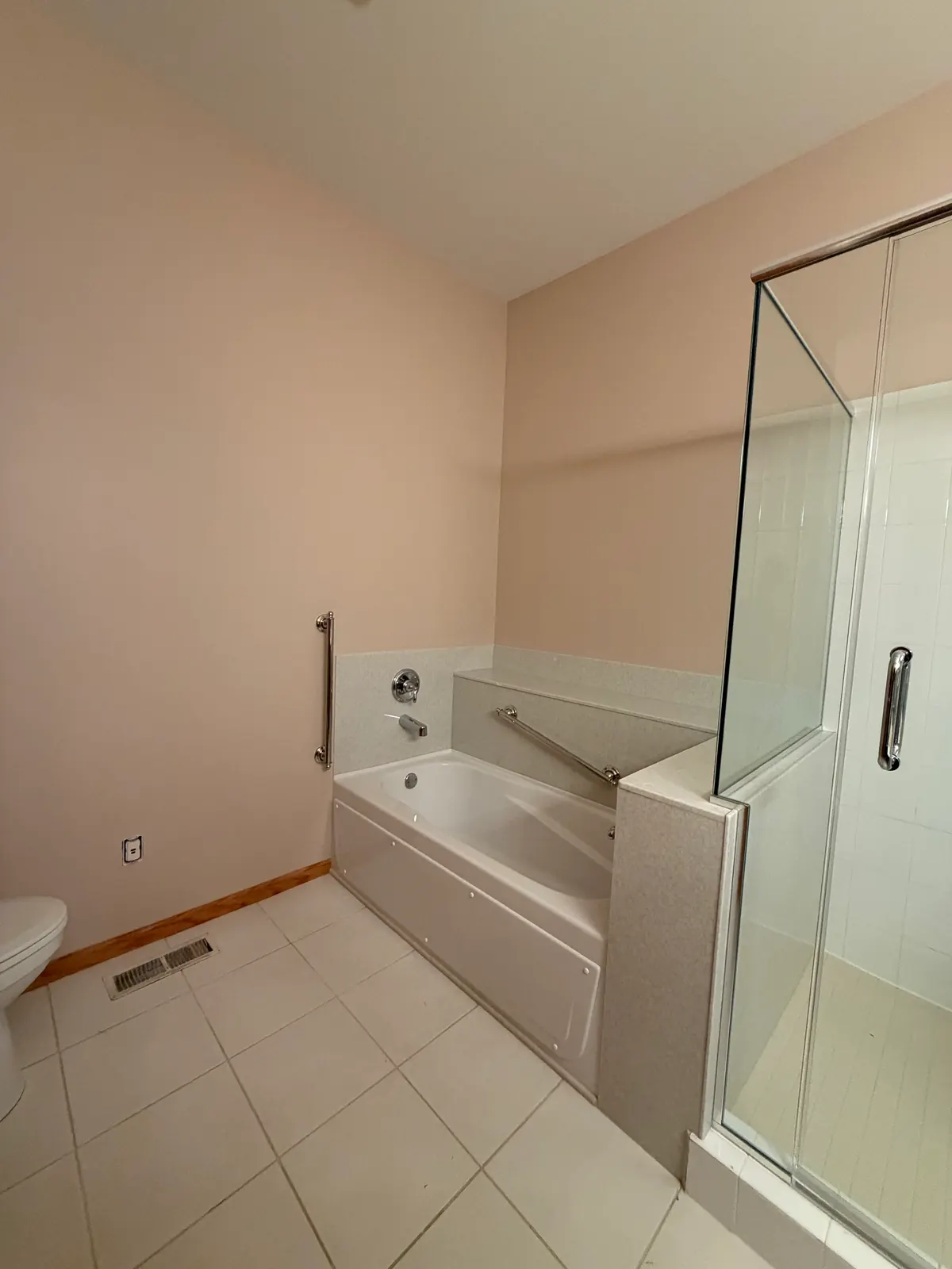The same Anoka townhome primary bathroom tub wall after painting, patches no longer visible.