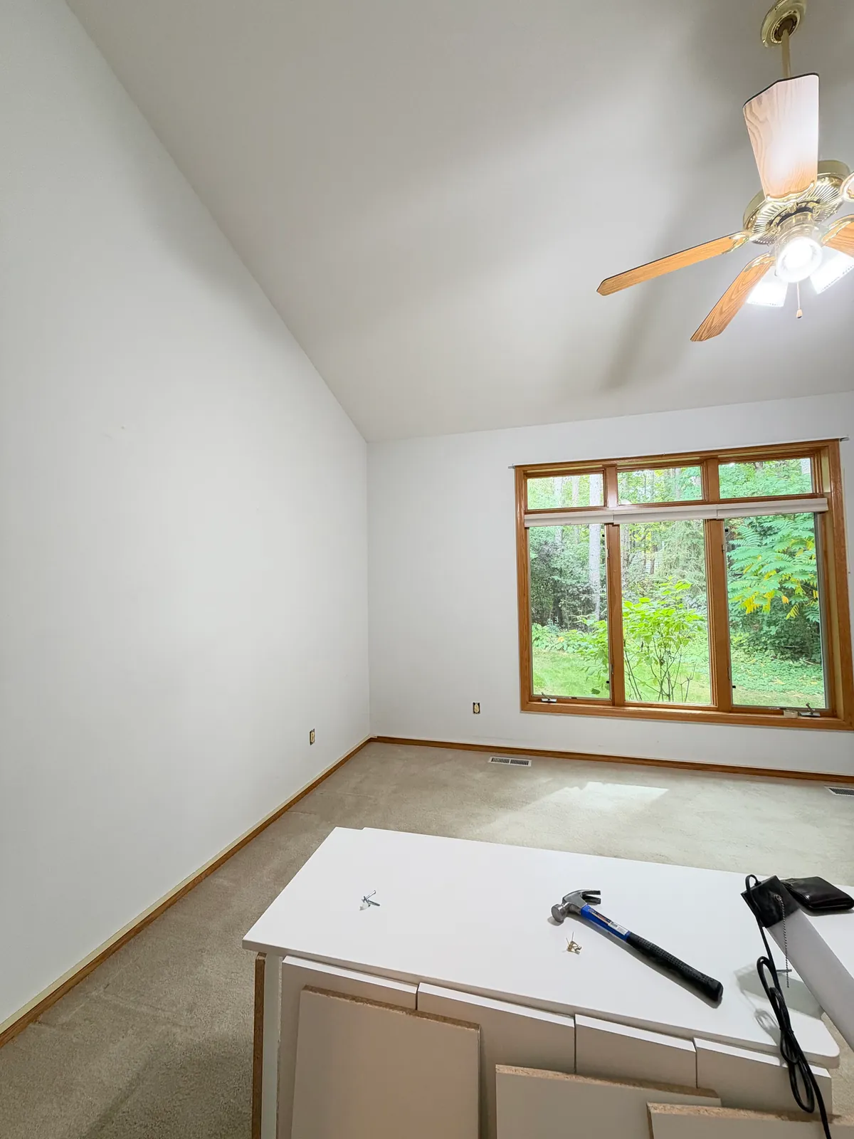 Anoka townhome primary bedroom before painting, white walls and a wood window.