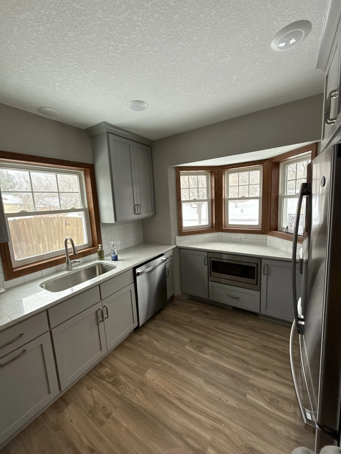 Coon Rapids kitchen with gray painted cabinets and a bay window.