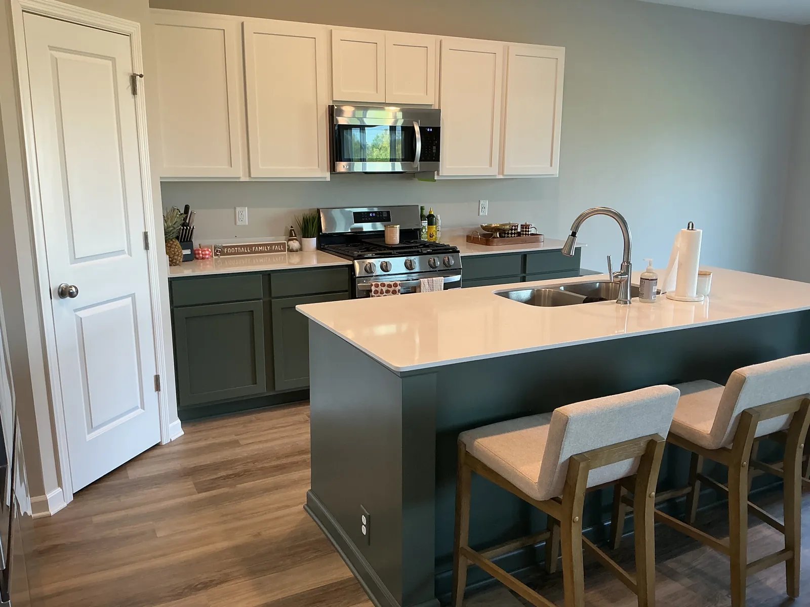 The same St. Michael kitchen with Pewter Green base cabinets and island refinished, and the existing white uppers.