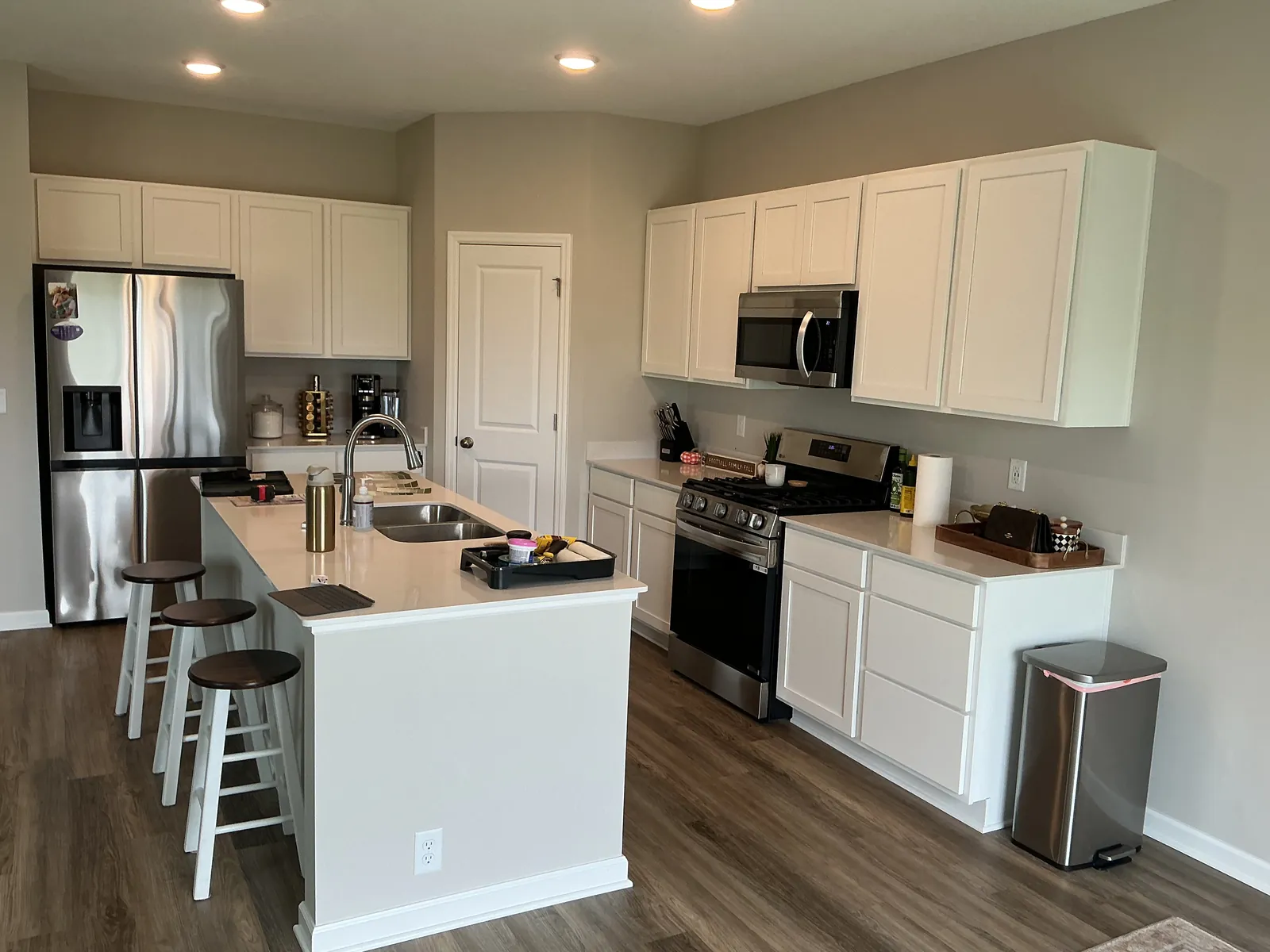 St. Michael kitchen before refinishing, seen from the other side of the island, with white base cabinets.